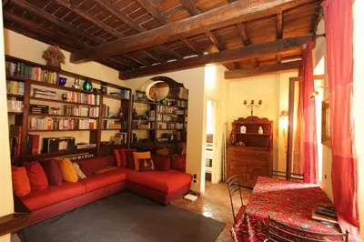 a living room with a red couch and book shelves at Bollo Studio in Rome