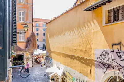 a group of people walking down a street next to a building at Sweet home Trastevere- Roma in Rome