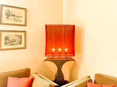a lamp in the corner of a room with two couches at Velabro Luxury Loft in Rome