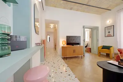 a living room with a table and a tv at YCH-Colorful and classy apartment near Fori Imperiali in Rome