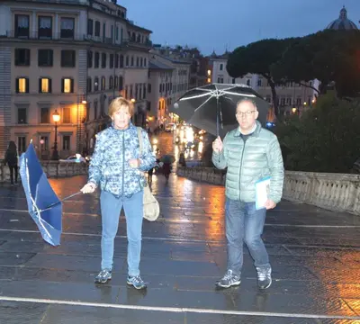 a man and a woman standing in the rain with umbrellas at Casa Vacanze Zio Gionni in Rome