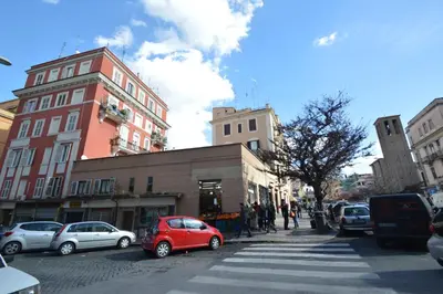 a red car parked on a city street with buildings at Casa Vacanze Zio Gionni in Rome