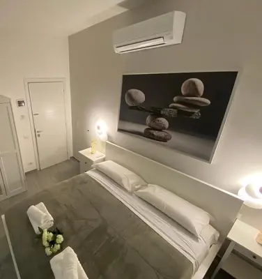 a bedroom with a bed and a painting on the wall at ROMA Guesthouse Affittacamere centro citta' SOFTROOMS-Metro' a 1 metro in Rome