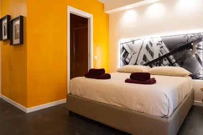 a bedroom with a large bed with yellow walls at Embassy Suites Roma in Rome