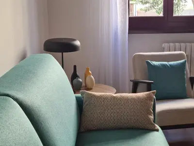 a living room with a green chair and a table at RomeBestHome Beccaria - Piazza del Popolo in Rome