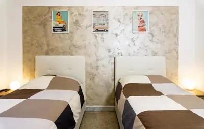 two beds sitting next to each other in a room at Pamphili Rooms in Rome