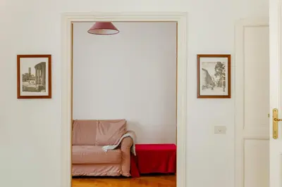 a person sitting on a couch in a living room at Charming apartment in a 1910s building 2 min walk from the Colosseum in Rome