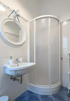 a white bathroom with a shower and a sink at Charming apartment in a 1910s building 2 min walk from the Colosseum in Rome