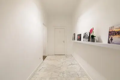 a hallway with white walls and a stone floor at Vatican Clodio Suites in Rome