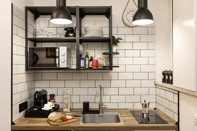 a kitchen with black and white tiled walls and a sink at Khris Home Apartments - Trastevere Parini in Rome