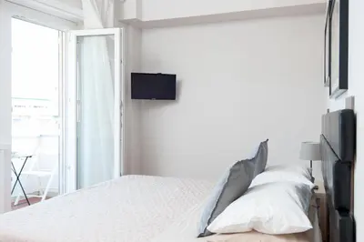 a bedroom with a bed with a tv on the wall at La Lanterna Di San Pietro in Rome