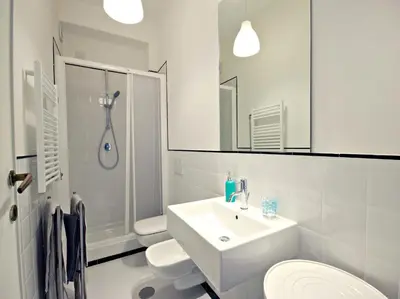 a white bathroom with a sink and two toilets at La Lanterna Di San Pietro in Rome