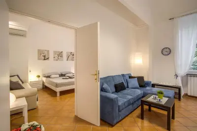a living room with a blue couch and a bed at Liberty House in Rome