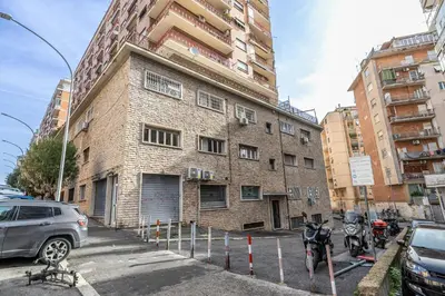 a brick building with cars parked in a parking lot at Dreamhome61 by Rentbeat in Rome