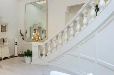a white staircase in a home with a mirror at The Great Beauty in Rome