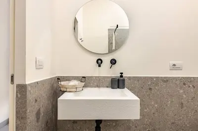 a bathroom with a white sink and a mirror at Boutique Via Veneto Apartment by SupaStays in Rome