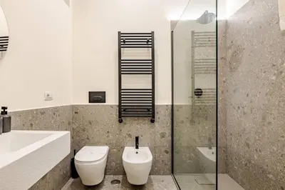 a bathroom with a toilet and a sink and a shower at Boutique Via Veneto Apartment by SupaStays in Rome