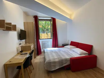 a bedroom with a bed and a desk and a window at Under Trastevere stars in Rome