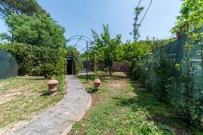 a garden with a brick path and a fence at Appia Antica Country House giardino parcheggio Fermata bus in Rome