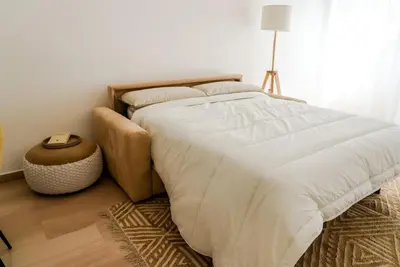 a bedroom with a bed with white sheets and a lamp at ophelia apartment in Rome