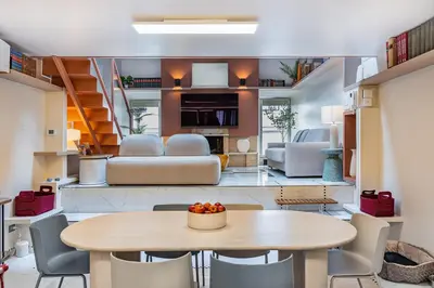 a dining room and living room with a table and chairs at Altiora - Luxury loft in Trastevere, Rome in Rome