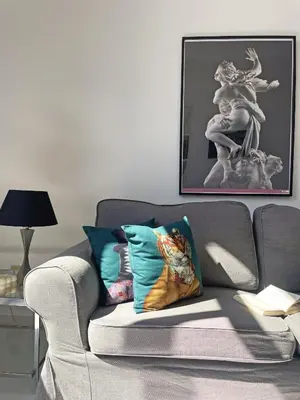 a living room with a gray couch with pillows at Trevi over the top apartment in Rome