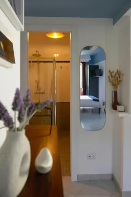 a room with a vase of flowers and a mirror at Bivio - Casa Azzurra in Rome