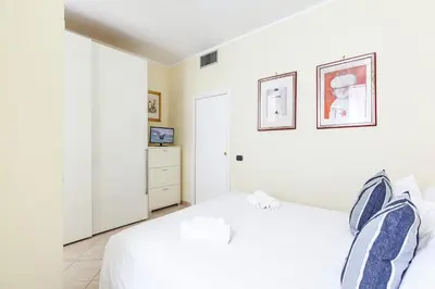 a white bedroom with a bed and a dresser at Hostly-Volturno Suite Apartment-Center of Rome in Rome