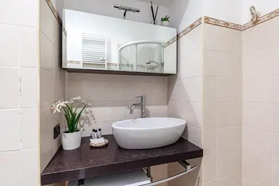 a bathroom with a sink and a mirror at Hostly-Volturno Suite Apartment-Center of Rome in Rome