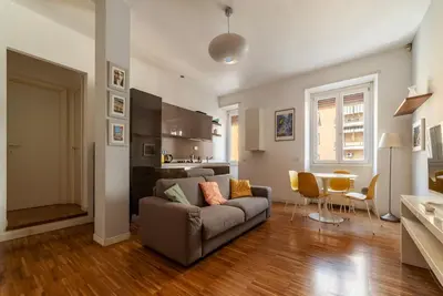 a living room with a couch and a table at GuestHost - Chic Stay at Magnagrecia Rome Apartment in Rome