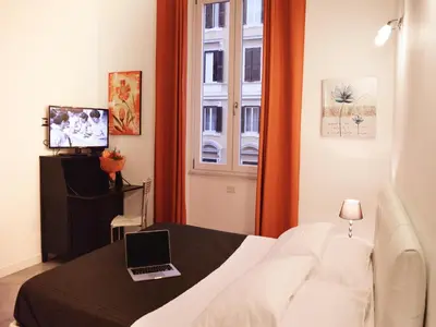 a bedroom with a bed with a laptop on it at La Torre Guest House in Rome
