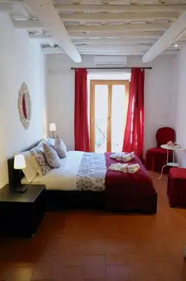 a bedroom with a large bed with red curtains at La Torre del Moro - RH Collection in Rome