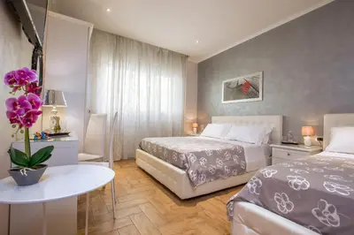 a room with a table and flowers on the wall at Starry Rome Guest House in Rome