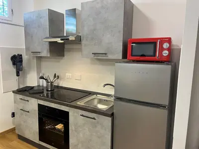 a kitchen with a refrigerator and a red microwave at AThome104 in Rome