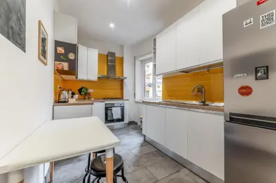 a kitchen with white cabinets and a white counter top at Casilina Green House - Metro Malatesta & Wi-Fi in Rome