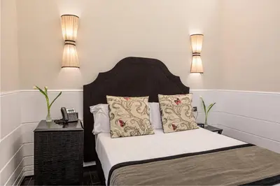 a bedroom with a bed with two lamps on it at The Independent Suites in Rome