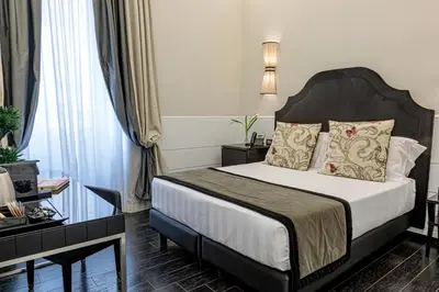 a hotel room with a bed and a table at The Independent Suites in Rome