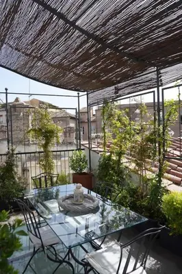 a patio with a glass table and chairs on a balcony at Vivi la Magia di Looney Tunes, piazza navona in Rome