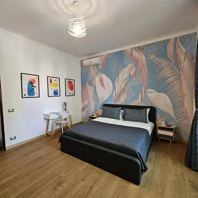 a bedroom with a large bed with a painting on the wall at The Place Milizie in Rome