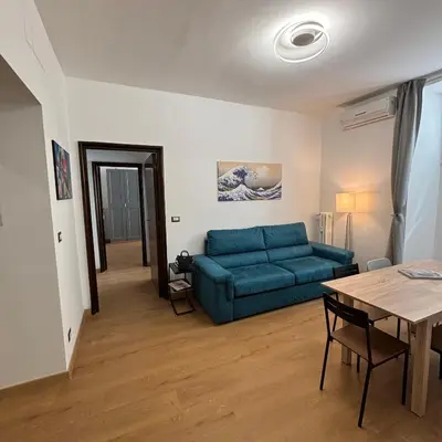a living room with a blue couch and a table at The Place Milizie in Rome