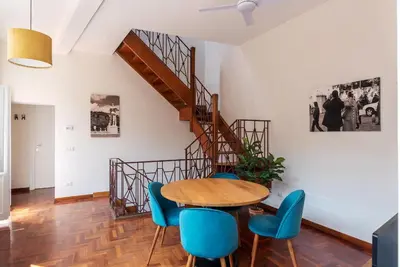 a dining room with a table and blue chairs at 2 BR Flat with Vatican Terrace in Rome