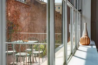 a balcony with a table and chairs and a vase at 2 BR Flat with Vatican Terrace in Rome