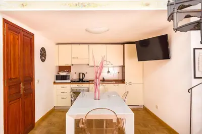 a kitchen with a white table with a vase on it at Trevispagna Charme Apartment Autonomous in Rome