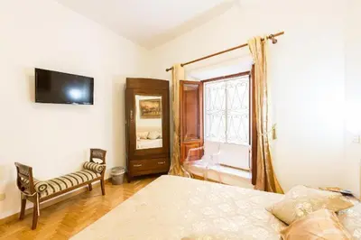 a bedroom with a bed and a tv and a window at Trevispagna Charme Apartment Autonomous in Rome
