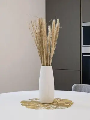 a white vase on a table with some dried grass at Stans Dolce Lusso Basilica San Giovanni in Rome
