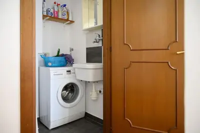 a bathroom with a washing machine and a sink at vatican house in Rome