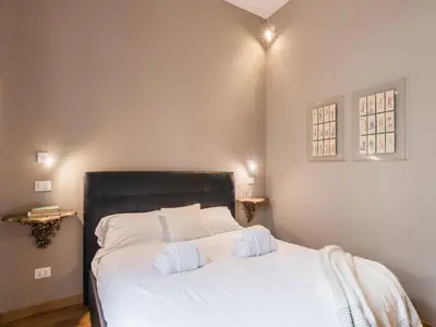 a bedroom with a bed with two towels on it at The Best Rent – Charming flat near Colosseo in Rome