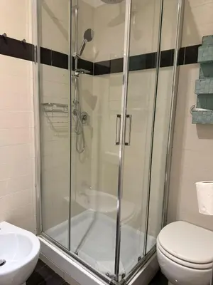 a bathroom with a shower and a toilet and a sink at Relais Merulana Guest House in Rome