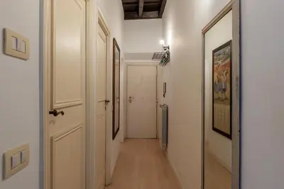 a hallway with white walls and a white door at GuestHost - Fori Imperiali Pretty Apartment in Rome