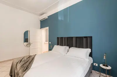a kitchen with white cabinets and an orange wall at The Best Rent – Bright three-bedroom apartment along the Tiber River in Rome